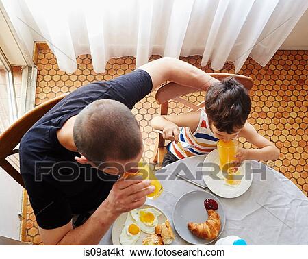 Stock Photograph - Father and son having breakfast. Fotosearch