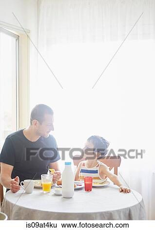 Stock Photograph - Father and son having breakfast. Fotosearch