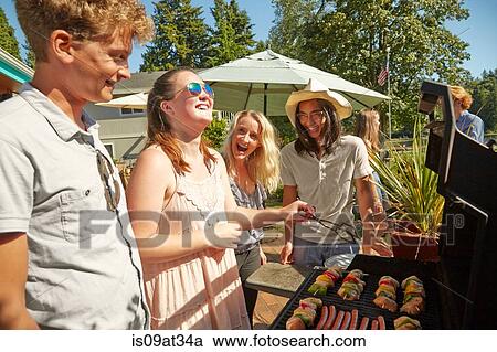 Stock Image - Friends at barbecue party. Fotosearch