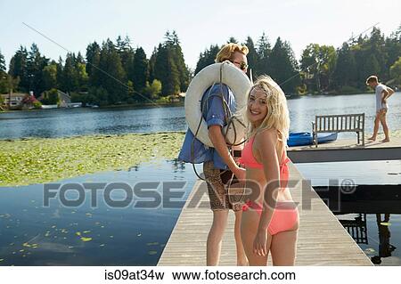 Stock Photo - "Friends going canoeing in lake, Seattle, Washington, USA". Fotosearch