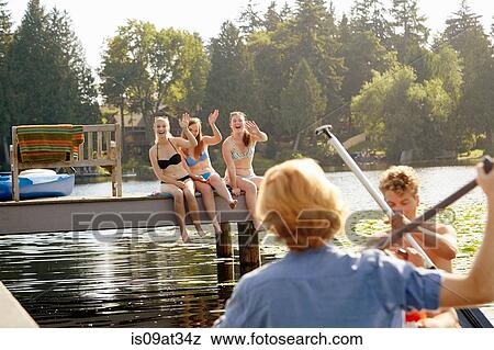 Stock Photo - "Friends rowing boat in lake, Seattle, Washington, USA". Fotosearch