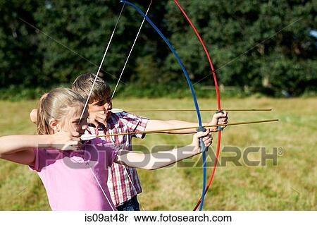Girl and teenage brother practicing archery View Large Photo Image Stock Photography - Girl and teenage brother practicing archery. Fotosearch