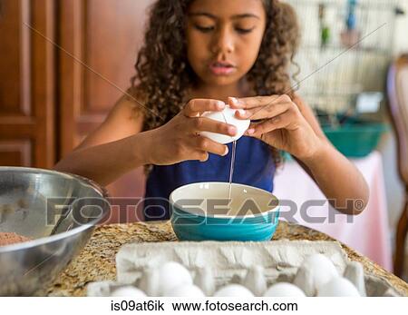 Girl cracking eggs into bowl looking down View Large Photo Image Stock Image - Girl cracking eggs into bowl looking down. Fotosearch