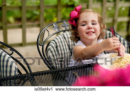 Girl dining at garden table looking at camera smiling View Large Photo Image Stock Image - Girl dining at garden table looking at camera smiling. Fotosearch