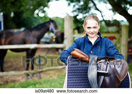 Girl horseback rider carrying saddle View Large Photo Image Stock Image - Girl horseback rider carrying saddle. Fotosearch