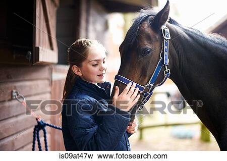 Girl horseback rider petting horse View Large Photo Image Stock Photo - Girl horseback rider petting horse. Fotosearch