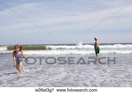 Girl playing and running in sea View Large Photo Image Stock Photo - Girl playing and running in sea. Fotosearch