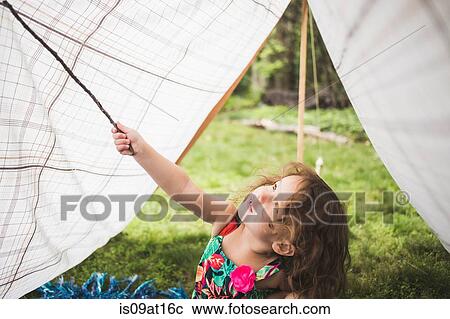 Girl poking homemade garden tent with twig View Large Photo Image Stock Image - Girl poking homemade garden tent with twig. Fotosearch