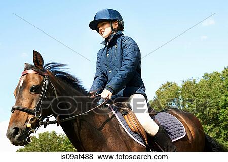 Stock Photo - Girl riding horse in countryside. Fotosearch