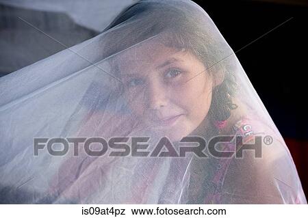 Girl underneath white netting looking at camera smiling View Large Photo Image Stock Photo - Girl underneath white netting looking at camera smiling. Fotosearch