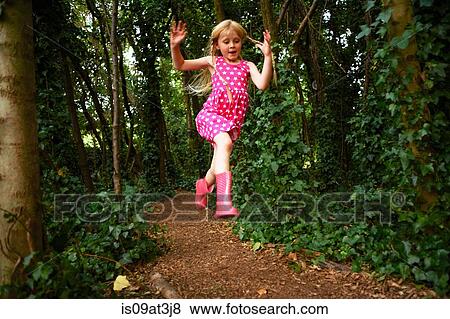 Girl wearing pink dress and rubber boots jumping in forest View Large Photo Image Stock Photo - Girl wearing pink dress and rubber boots jumping in forest. Fotosearch