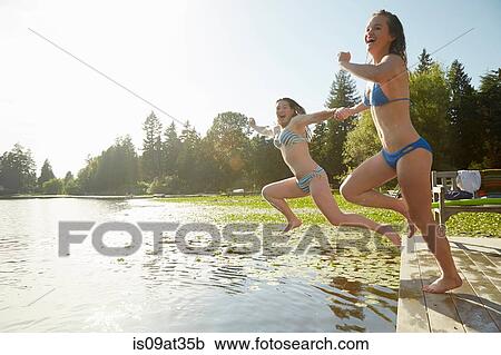 "Girls in bikini jumping into lake, Seattle, Washington, USA" View Large Photo Image Stock Image - "Girls in bikini jumping into lake, Seattle, Washington, USA". Fotosearch