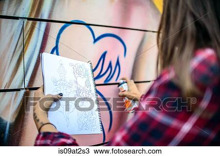 Stock Image - "Graffiti artist spray painting wall, Venice Beach, California, USA". Fotosearch