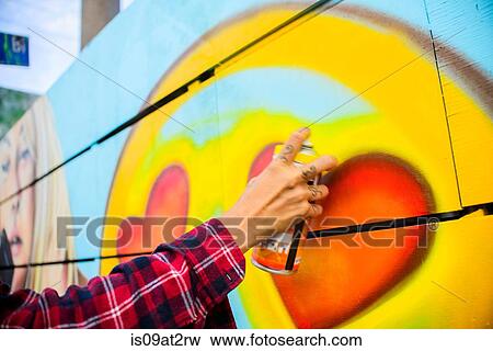 Stock Photo - "Graffiti artist spray painting wall, Venice Beach, California, USA". Fotosearch