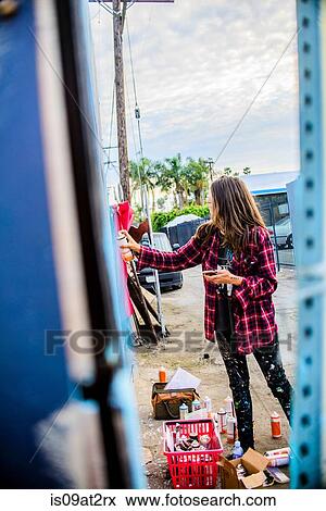 Stock Photo - "Graffiti artist spray painting wall, Venice Beach, California, USA". Fotosearch