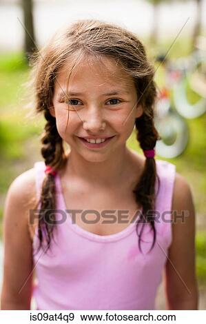 Stock Photo - High angle portrait of young girl with pigtails looking at camera smiling. Fotosearch