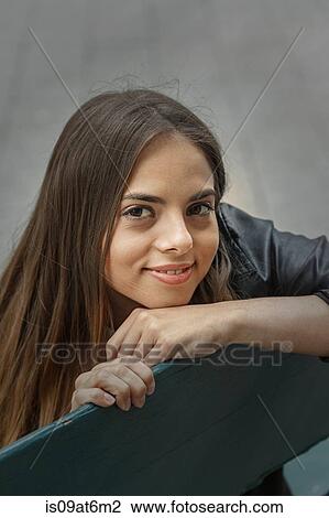 High angle portrait of young woman chin on hand looking at camera smiling View Large Photo Image Stock Image - High angle portrait of young woman chin on hand looking at camera smiling. Fotosearch