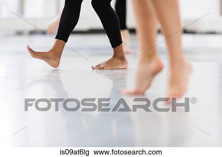 Stock Image - Legs and bare feet of young women dancers dancing. Fotosearch