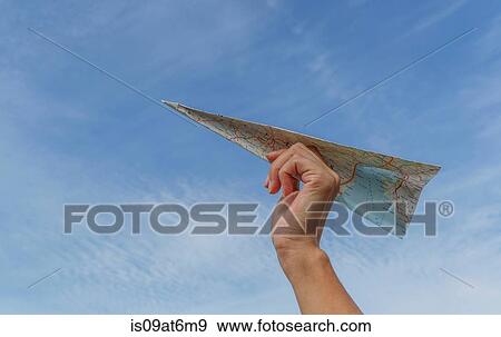 Low angle view of blue sky and womans hand holding paper airplane made from map View Large Photo Image Stock Photo - Low angle view of blue sky and womans hand holding paper airplane made from map. Fotosearch