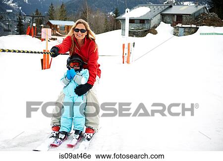 Stock Image - "Male toddler in front of mother moving up on ski rope, Les Arcs, Villaroger, Savoie, France". Fotosearch