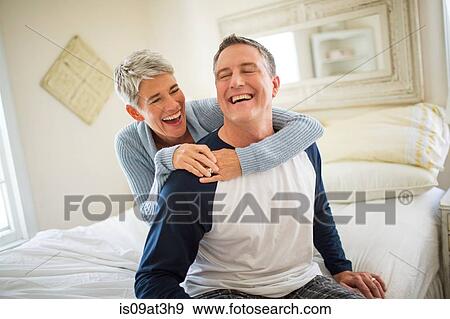 Mature couple laughing and fooling around on bed View Large Photo Image Stock Photo - Mature couple laughing and fooling around on bed. Fotosearch