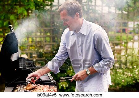 Mature man cooking seafood on barbecue View Large Photo Image Stock Photography - Mature man cooking seafood on barbecue. Fotosearch