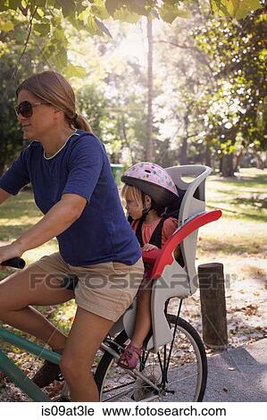 Mature woman on bicycle with daughter sitting in child's seat behind her View Large Photo Image Stock Image - Mature woman on bicycle with daughter sitting in child's seat behind her. Fotosearch