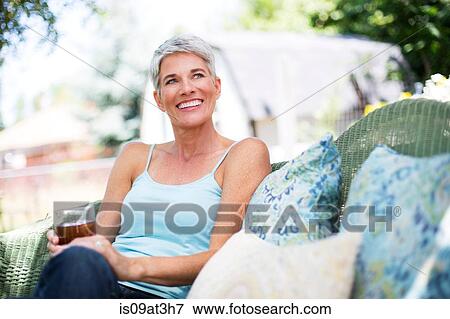Mature woman relaxing on garden seat View Large Photo Image Stock Photo - Mature woman relaxing on garden seat. Fotosearch