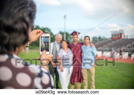Mature woman taking family portrait at graduation ceremony View Large Photo Image Stock Image - Mature woman taking family portrait at graduation ceremony. Fotosearch