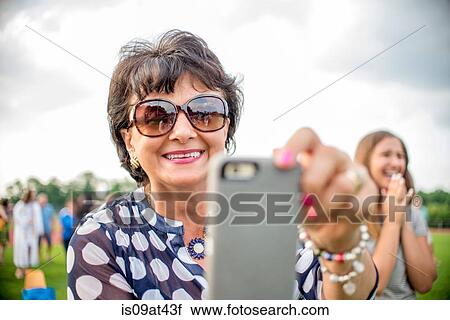 Mature woman taking photograph with smartphone View Large Photo Image Stock Image - Mature woman taking photograph with smartphone. Fotosearch