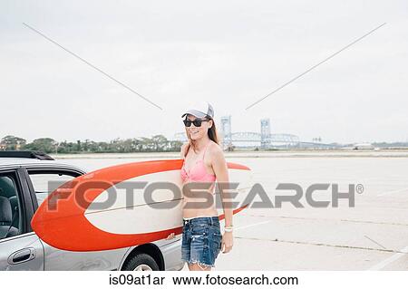 "Mid adult woman at beach, holding surfboard" View Large Photo Image Stock Photography - "Mid adult woman at beach, holding surfboard". Fotosearch