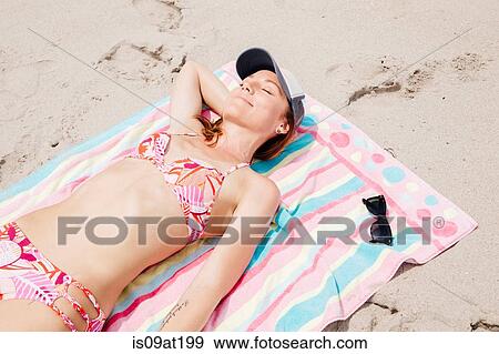 Mid adult woman lying on beach View Large Photo Image Stock Photo - Mid adult woman lying on beach. Fotosearch