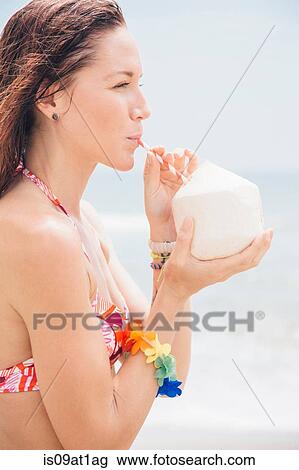 "Mid adult woman on beach, drinking from coconut" View Large Photo Image Stock Image - "Mid adult woman on beach, drinking from coconut". Fotosearch