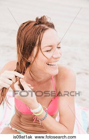 "Mid adult woman on beach, plaiting hair" View Large Photo Image Stock Image - "Mid adult woman on beach, plaiting hair". Fotosearch