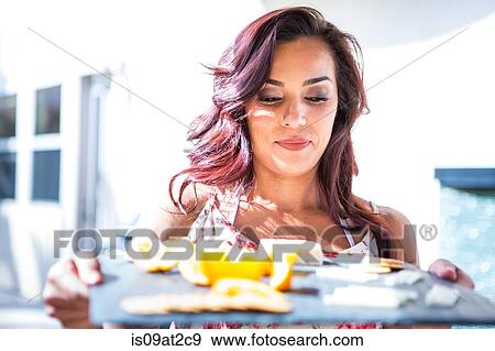 Mid adult woman serving biscuit and cheese board on patio View Large Photo Image Stock Photo - Mid adult woman serving biscuit and cheese board on patio. Fotosearch