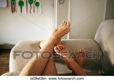 Picture - "Mother and son relaxing on sofa, feet up, focus on feet". Fotosearch