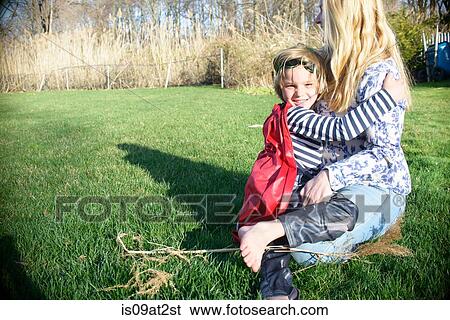 Mother hugging son in red superhero cape View Large Photo Image Stock Photograph - Mother hugging son in red superhero cape. Fotosearch