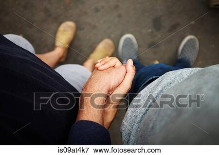 Overhead view of couple holding hands View Large Photo Image Stock Photo - Overhead view of couple holding hands. Fotosearch