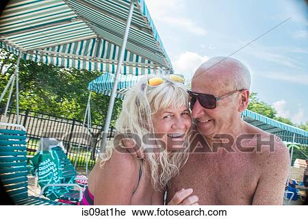 Portrait of affectionate senior couple sitting poolside at outdoor swimming pool View Large Photo Image Stock Image - Portrait of affectionate senior couple sitting poolside at outdoor swimming pool. Fotosearch