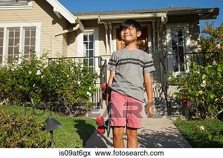 Portrait of boy with skateboard in garden View Large Photo Image Stock Photo - Portrait of boy with skateboard in garden. Fotosearch