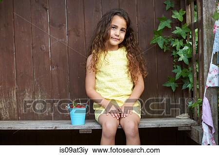Portrait of girl sitting on bench with a bucket of fresh strawberries View Large Photo Image Stock Photo - Portrait of girl sitting on bench with a bucket of fresh strawberries. Fotosearch