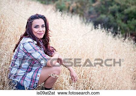 Portrait of mid adult woman sitting in long grass View Large Photo Image Stock Photograph - Portrait of mid adult woman sitting in long grass. Fotosearch