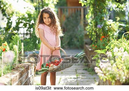 Portrait of pretty girl holding basket of fresh vegetables in garden View Large Photo Image Stock Photograph - Portrait of pretty girl holding basket of fresh vegetables in garden. Fotosearch