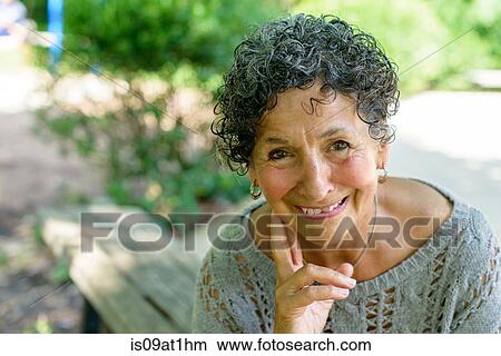 Picture - Portrait of senior woman sitting in park. Fotosearch