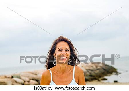 Stock Photo - "Portrait of smiling mature woman at coast, Cape Cod, USA". Fotosearch