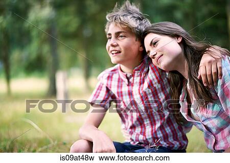 Stock Photo - Portrait of teenage boy with arm around sister. Fotosearch