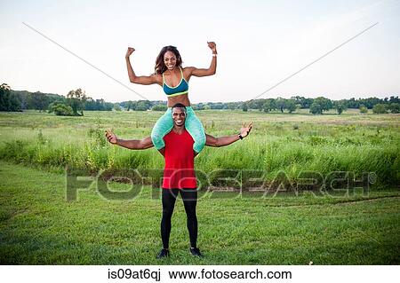 Portrait of young man training with girlfriend on his shoulders View Large Photo Image Stock Image - Portrait of young man training with girlfriend on his shoulders. Fotosearch