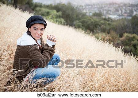 Portrait of young woman wearing a cap on grassy hill View Large Photo Image Stock Photography - Portrait of young woman wearing a cap on grassy hill. Fotosearch