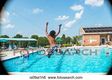Rear view of boy jumping into outdoor swimming pool View Large Photo Image Stock Photograph - Rear view of boy jumping into outdoor swimming pool. Fotosearch