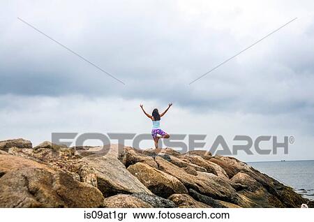 "Rear view of mature woman practicing yoga on coastal rocks, Cape Cod, USA" View Large Photo Image Stock Photography - "Rear view of mature woman practicing yoga on coastal rocks, Cape Cod, USA". Fotosearch